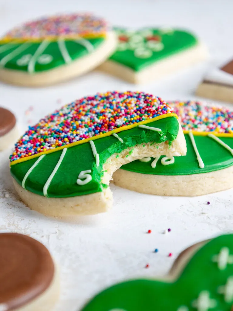 image of a bitten into cream cheese cookie that's been decorated to look like a football field