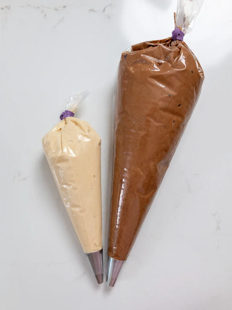 image of chocolate and peanut butter buttercream in piping bags