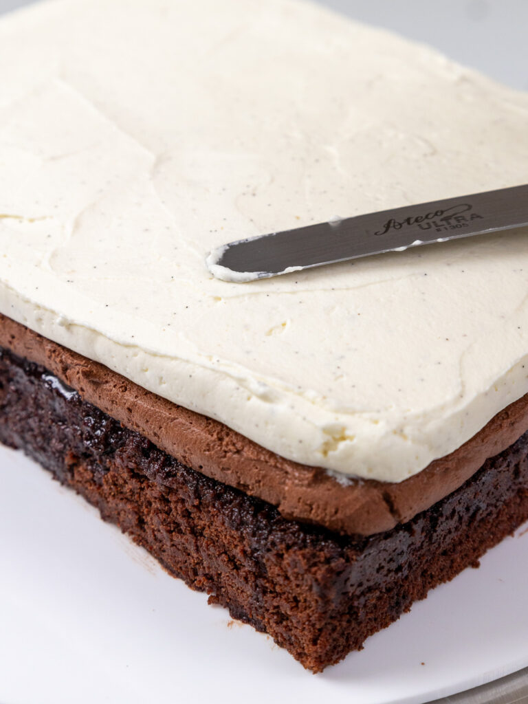 image of a chocolate tuxedo cake being filled with dark and white chocolate mousse