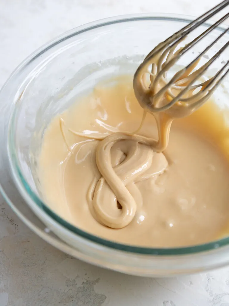 image of vanilla royal icing that's been thinned out to a flood consistency and is ready to be used to decorate macaron shells