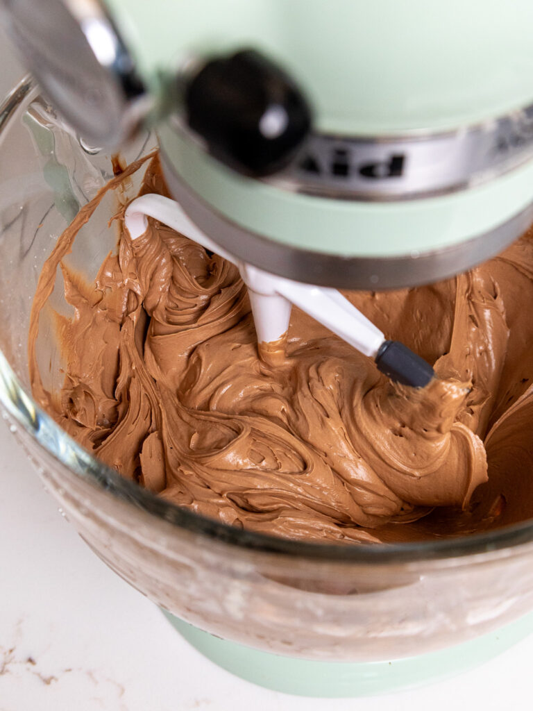 image of not too sweet chocolate frosting being mixed in a stand mixer with a paddle attachment