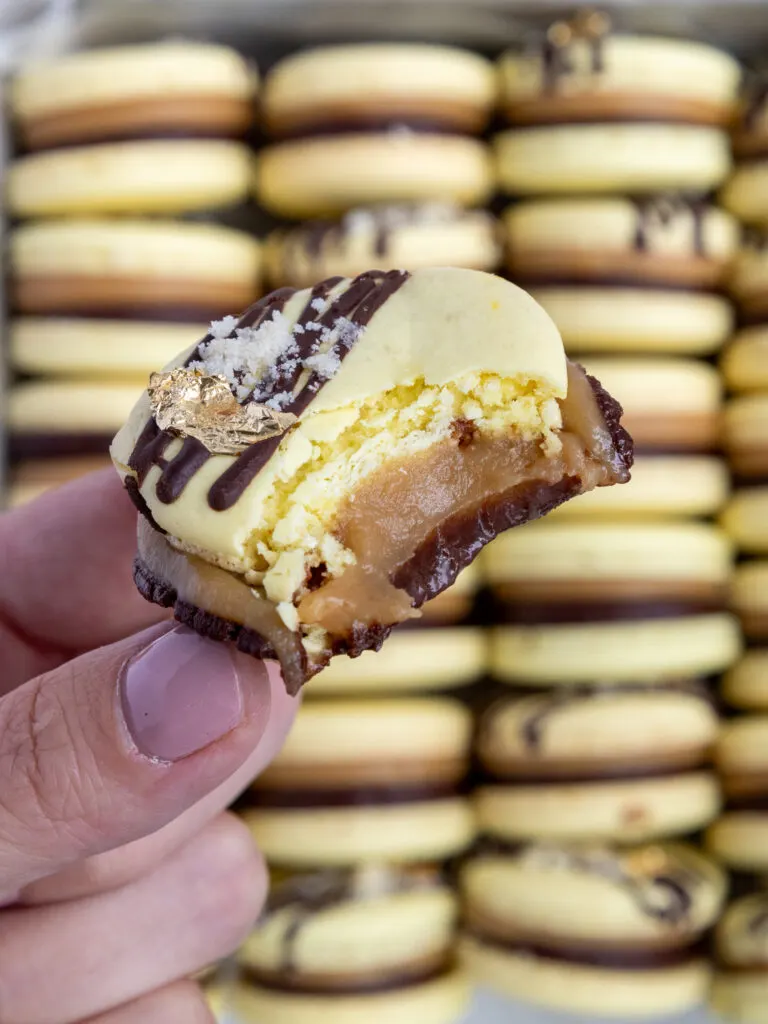 image of a caramel and chocolate macaron that's been bitten into