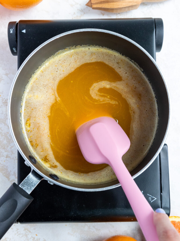image of orange curd cooking in a saucepan