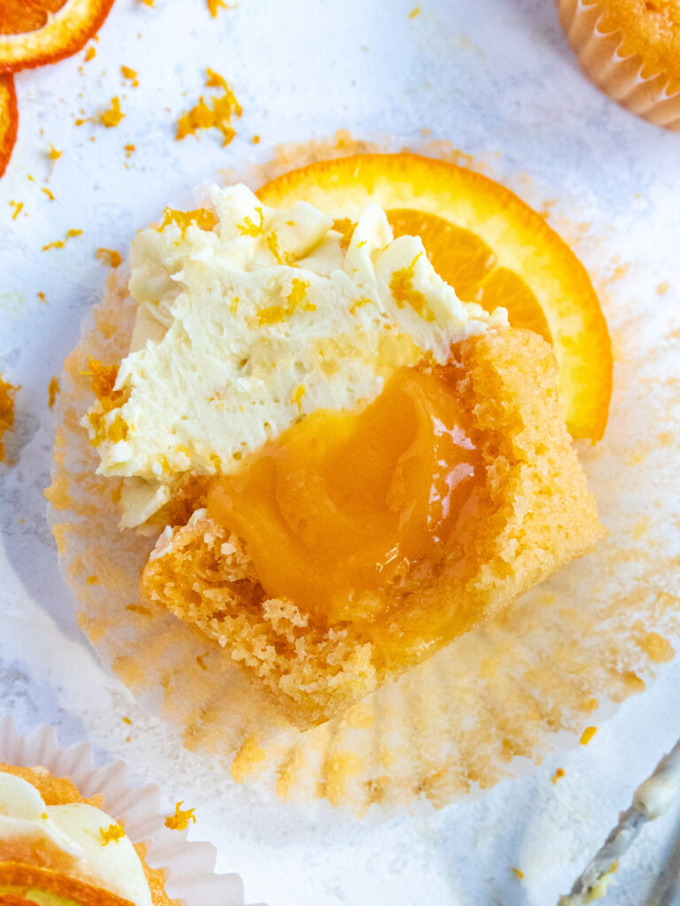 image of an orange cupcake that's been cut in half to show its orange curd filling
