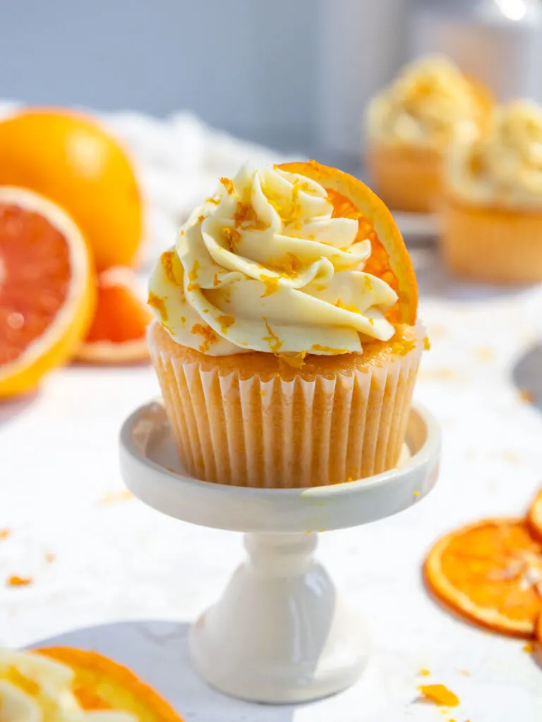 image of an orange cupcake that's filled with orange curd and frosted with orange buttercream