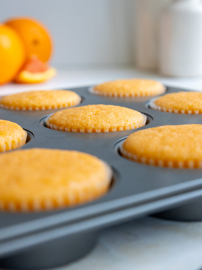image of orange cupcakes that have been baked and are cooling in the pan