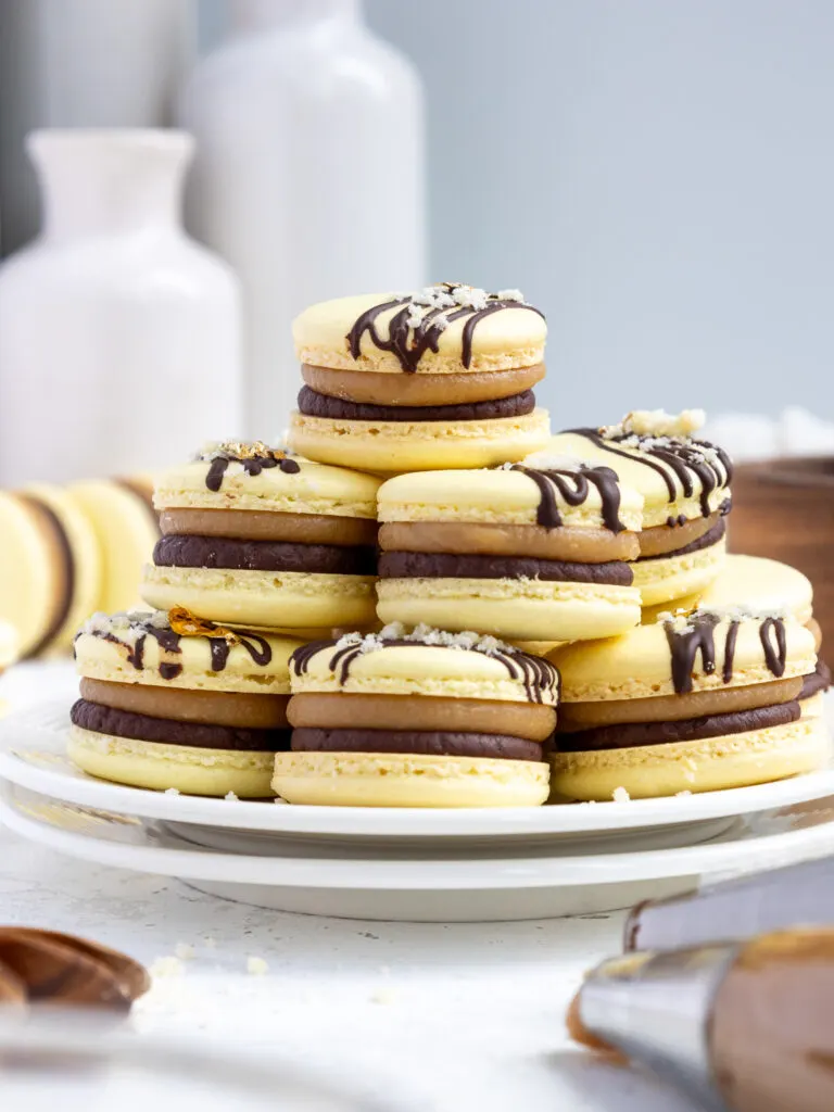 image of millionaire macarons stacked together in a tray to show their caramel and chocolate filling