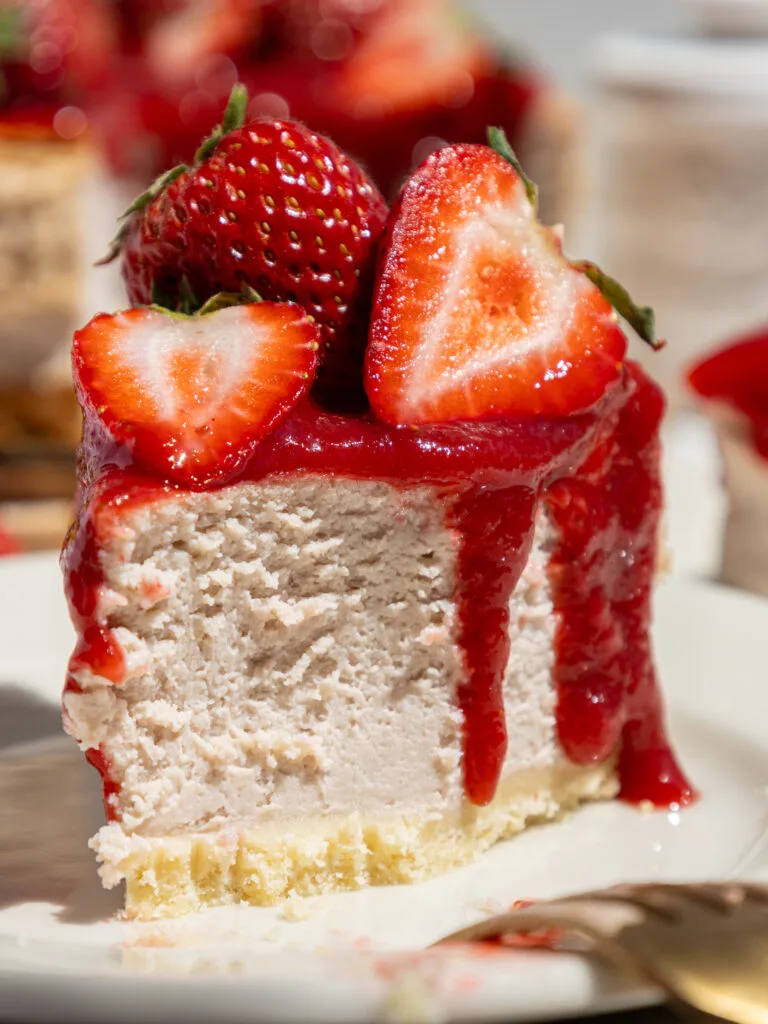 image of a slice of strawberry cheesecake that's been cut into to show how fluffy and light its texture is