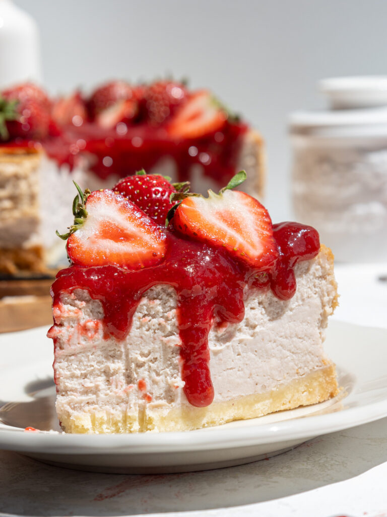 image of a slice of strawberry cheesecake that's been cut into to show how fluffy and light its texture is