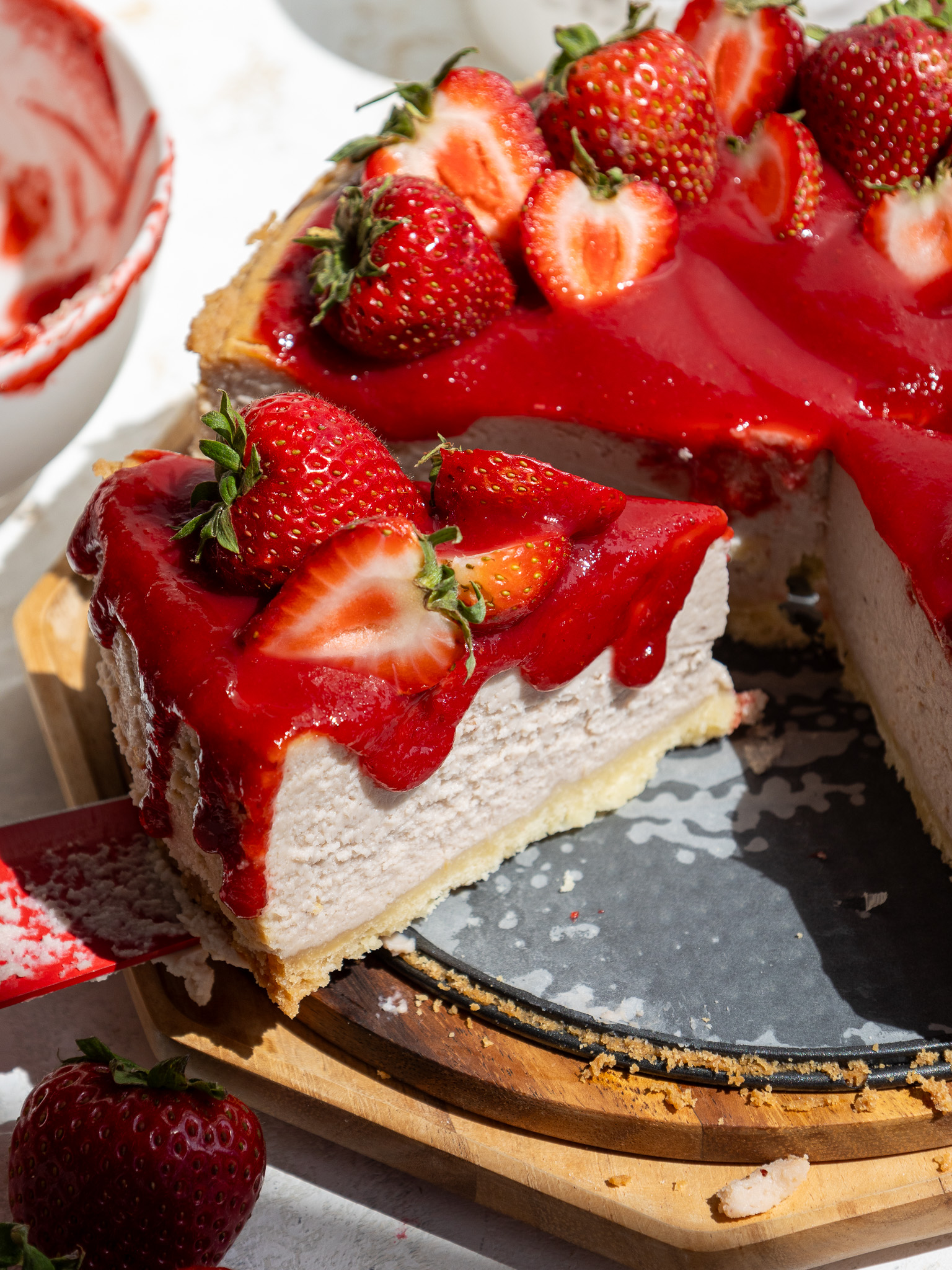 image of a slice of strawberry cheesecake being cut