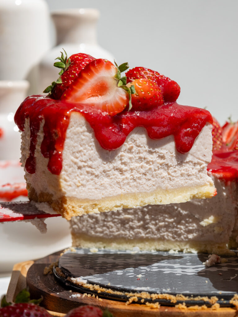 image of a slice of strawberry cheesecake being cut