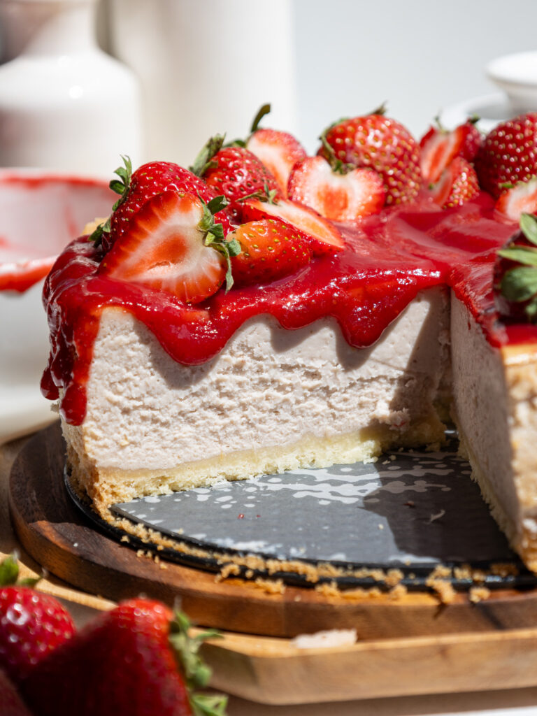 image of a slice of strawberry cheesecake being cut