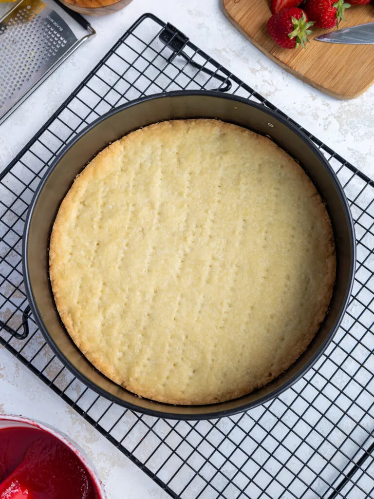 image of a baked shortbread cheesecake crust cooling on a wire rack