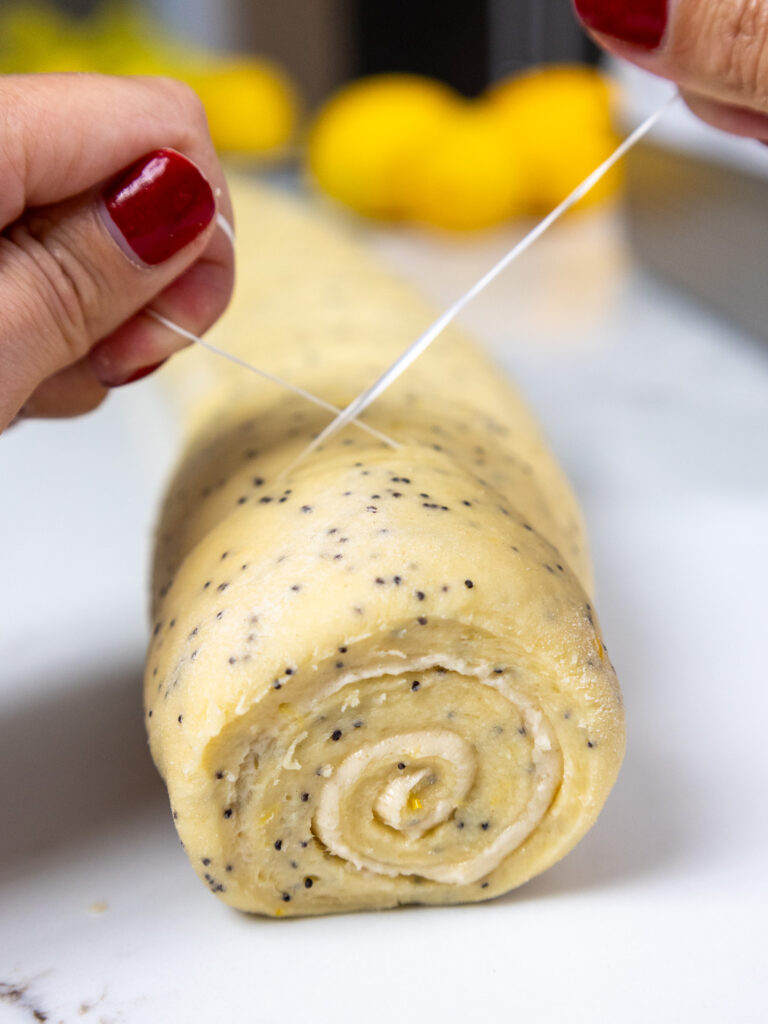 image of lemon poppyseed rolls being cut with dental floss