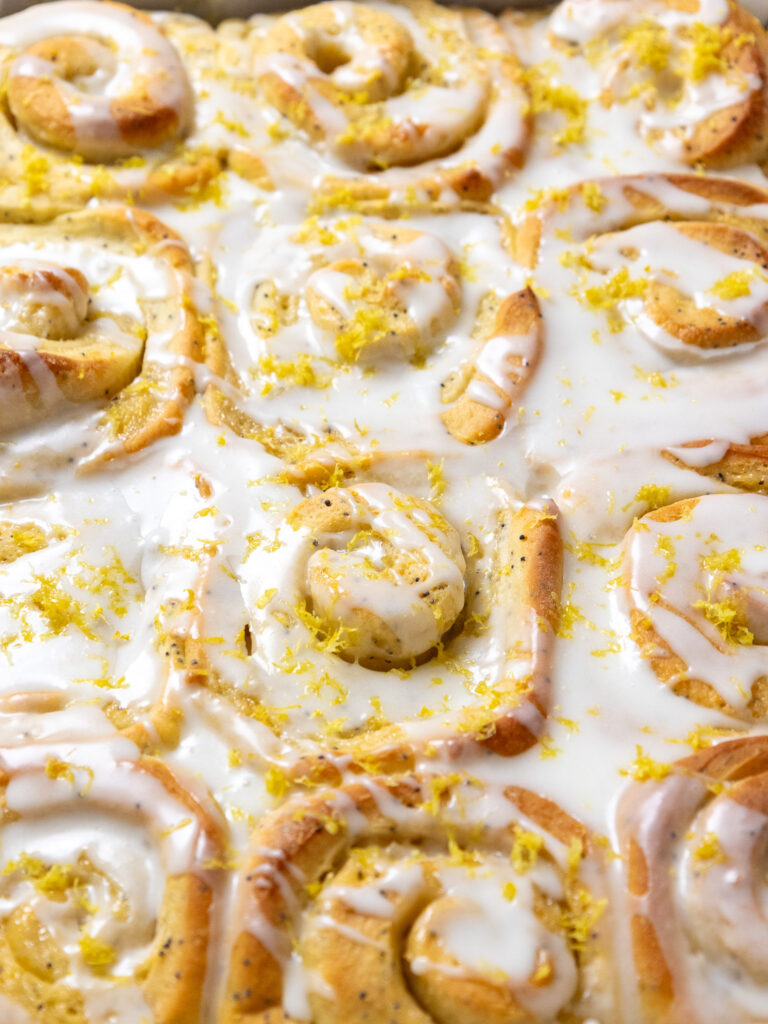 image of lemon rolls that have been iced with lemon icing and topped with lemon zest