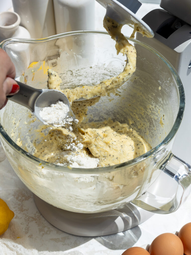 image of flour being added to lemon poppyseed roll dough