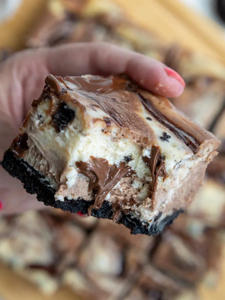 image of nutella cheesecake bar that's been bitten into to show it's nutella swirls