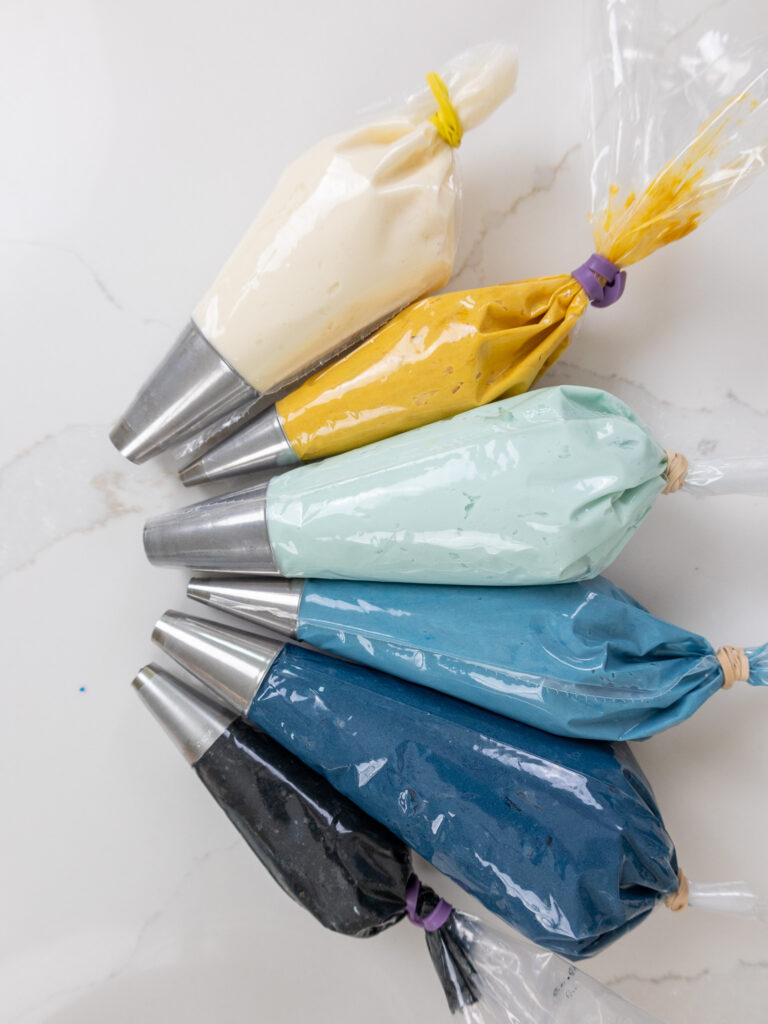 image of buttercream colored with gel food coloring and placed in piping bags to make a Bluey cake