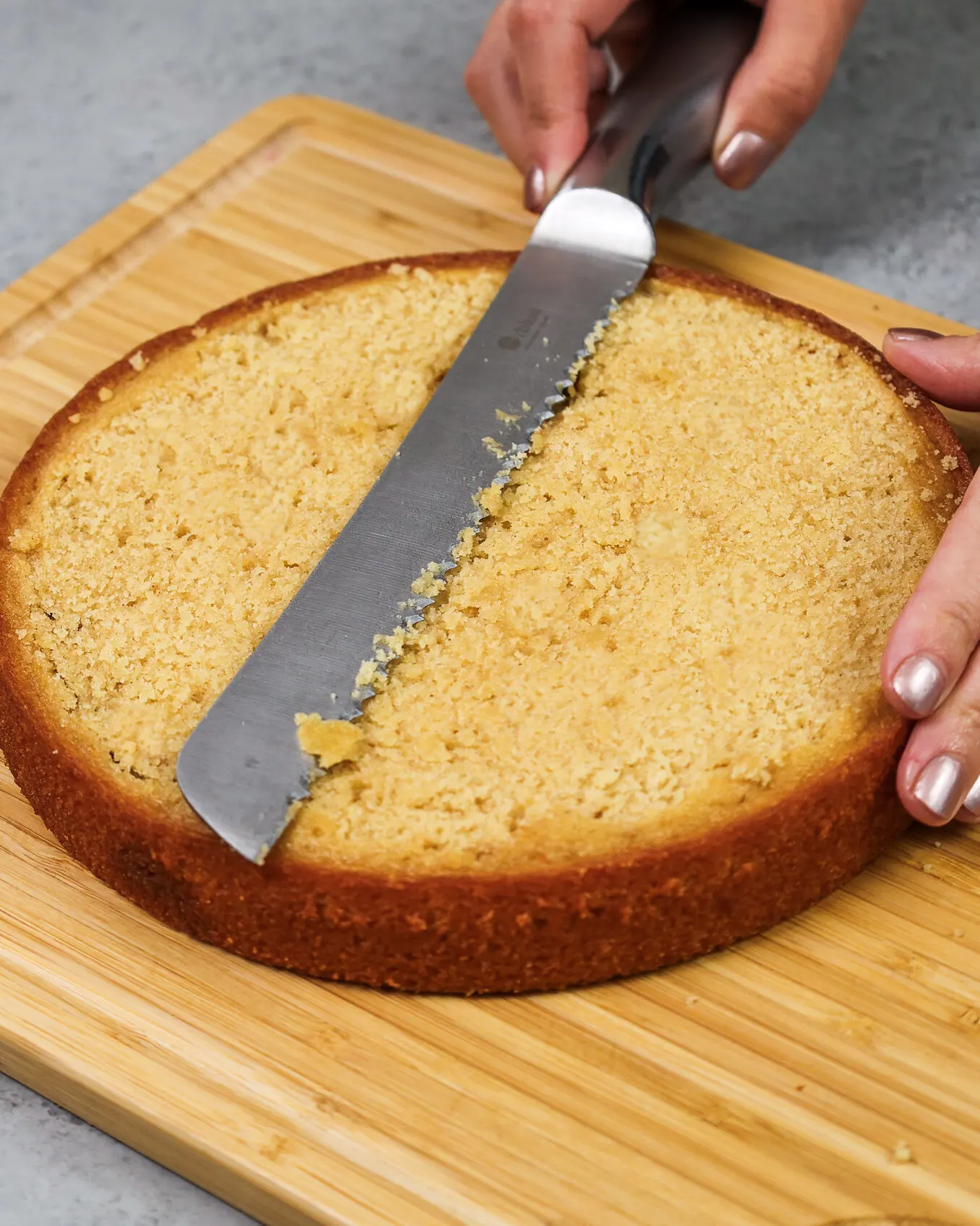 image of a brown sugar cake layer being leveled with a serrated knife