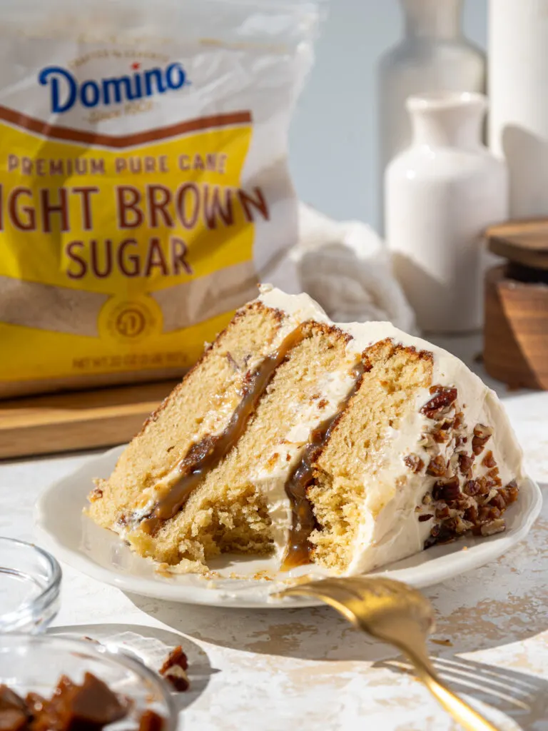 image of a slice of butterscotch toffee cake on a plate that's been cut into to show it's delicious filling