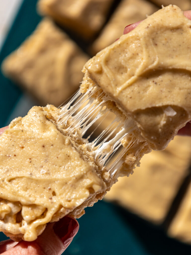 image of brown butter rice krispies being pulled apart with gooey marshmallows