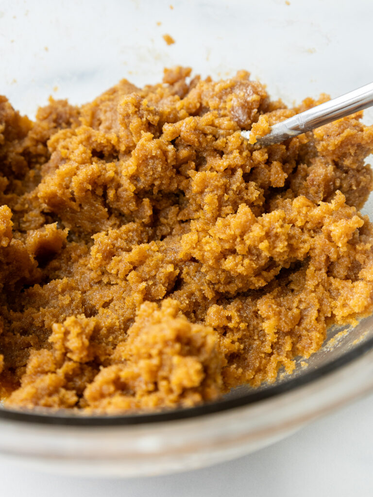 image of pumpkin cake pop dough that's been mixed in a glass bowl and is ready to be scooped