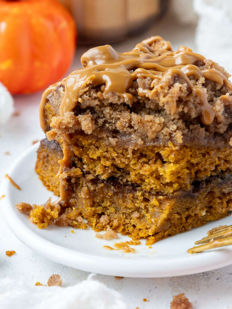 image of a piece of pumpkin coffee cake that's been cut into to show how moist it is