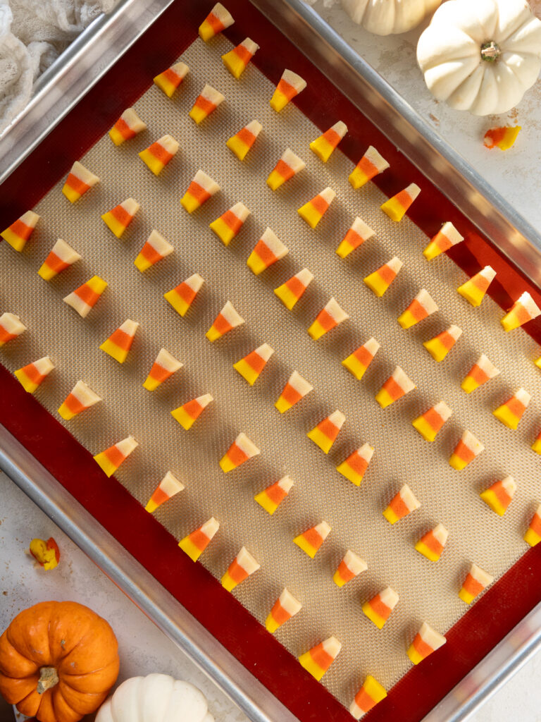 image of candy corn cookies that have been baked and are cooling on baking mat