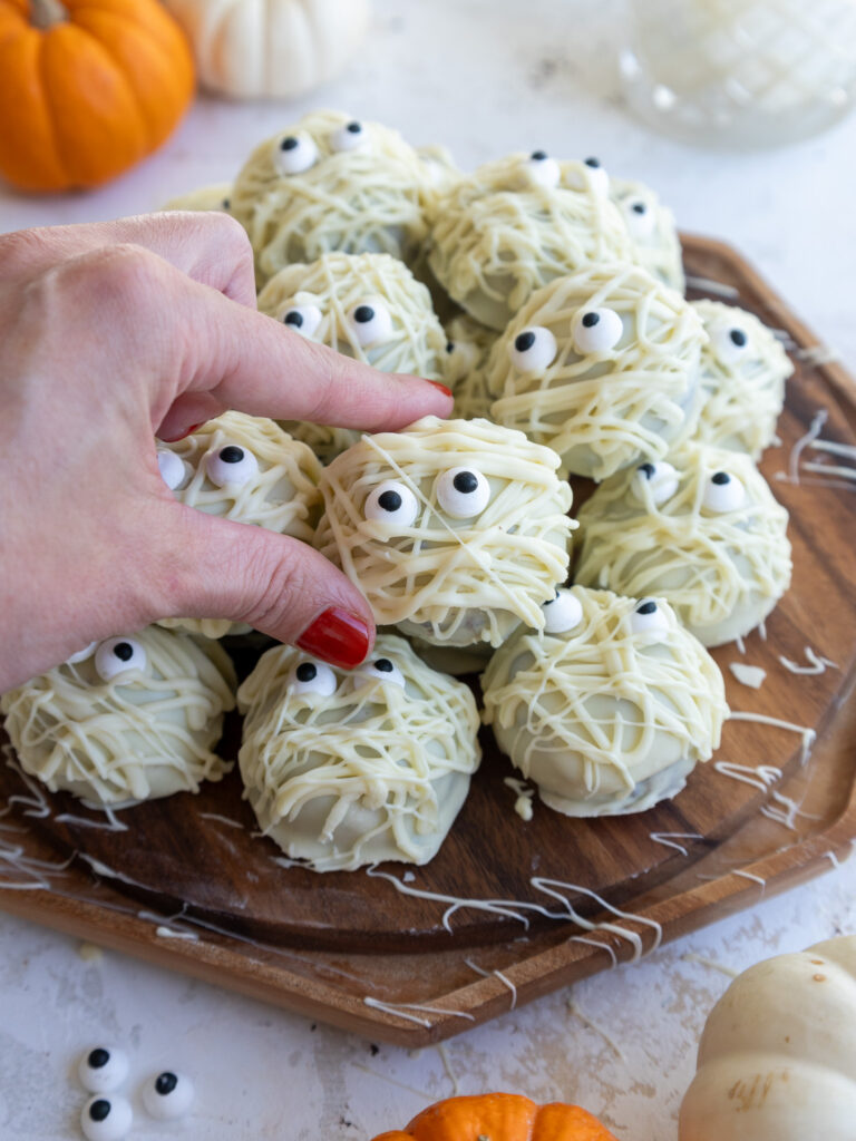 image of mummy cake pops set on a wooden platter