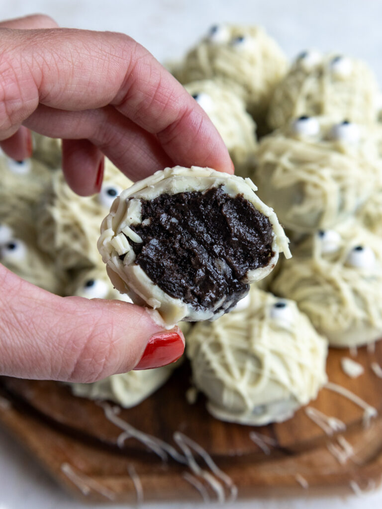 image of a mummy cake pop that's been bitten into to show its Oreo center