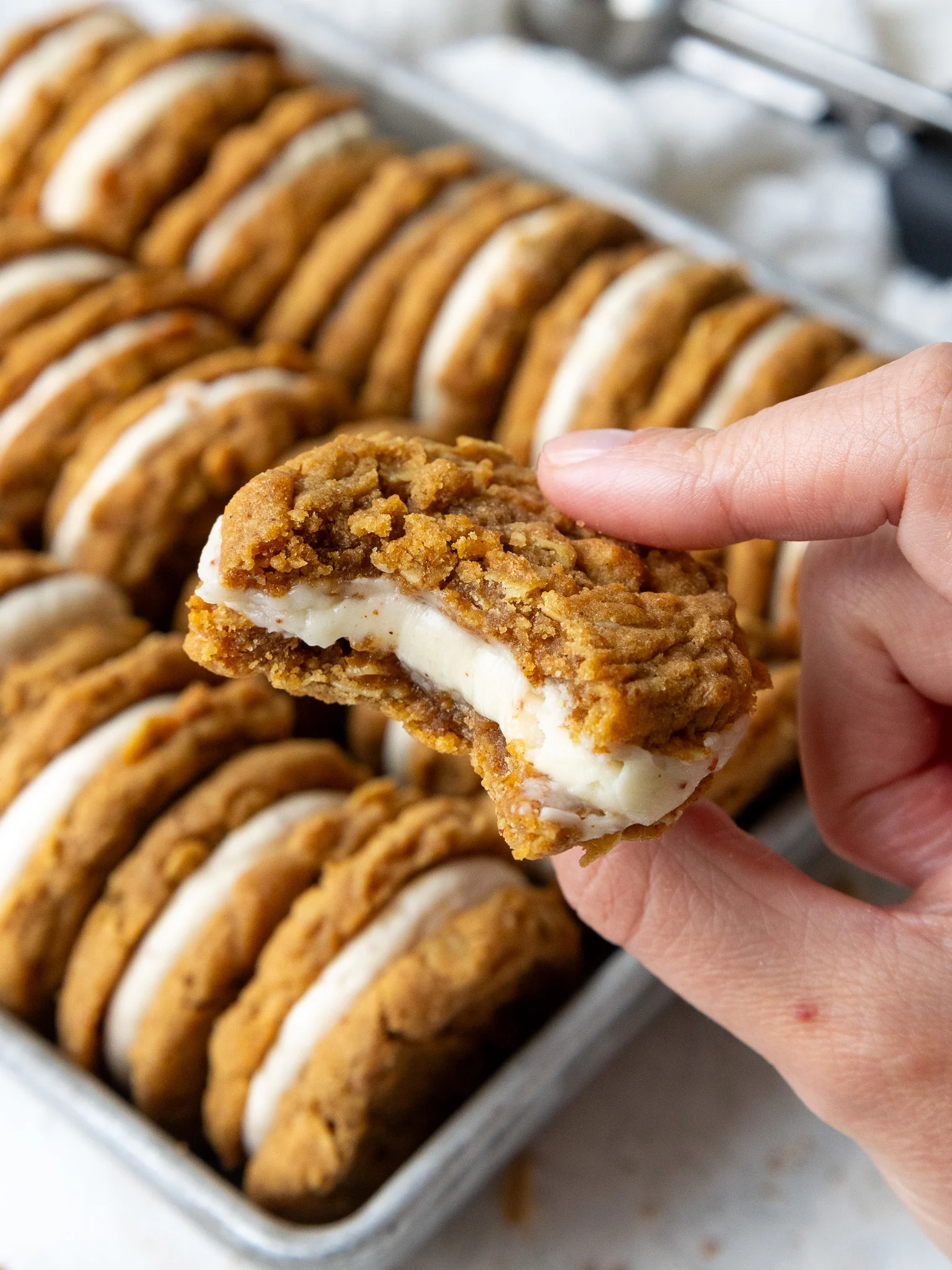 image of an oatmeal sandwich cookie filled with brown butter cream cheese frosting