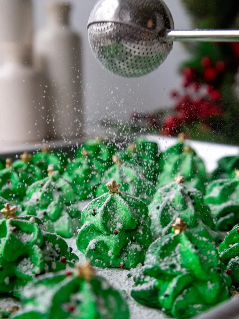 image of powdered sugar being dusted on meringue trees