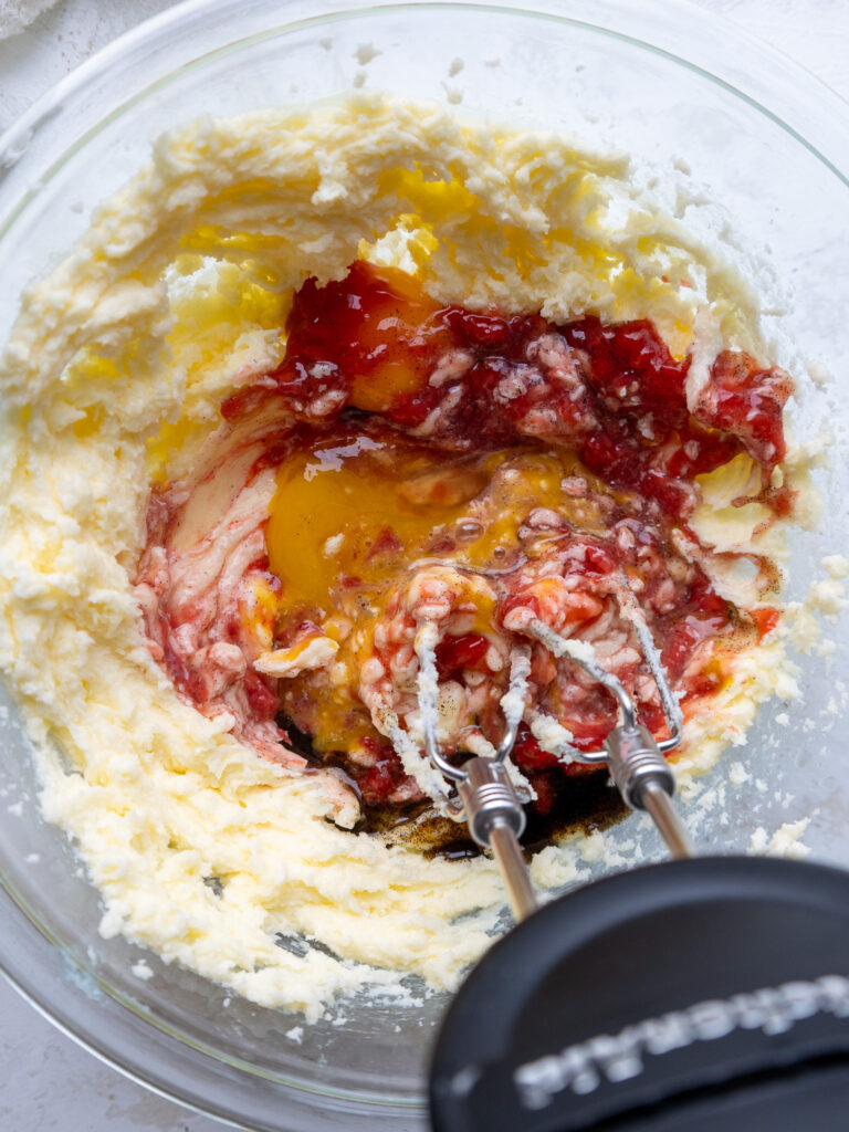 image of wet ingredients being mixed into butter and sugar