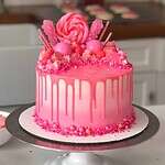 image of a pink drip cake that's been decorated with candy