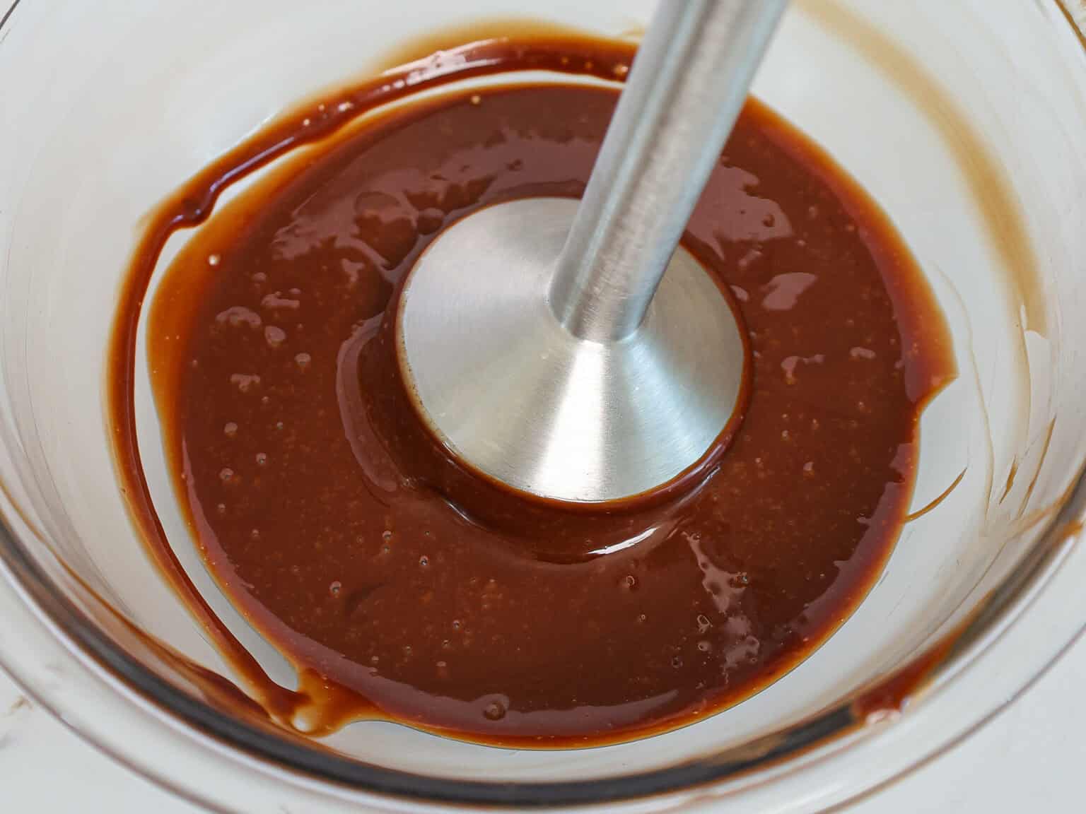 image of chocolate ganache filling for macarons that's being mixed with an immersion blender to make it super smooth