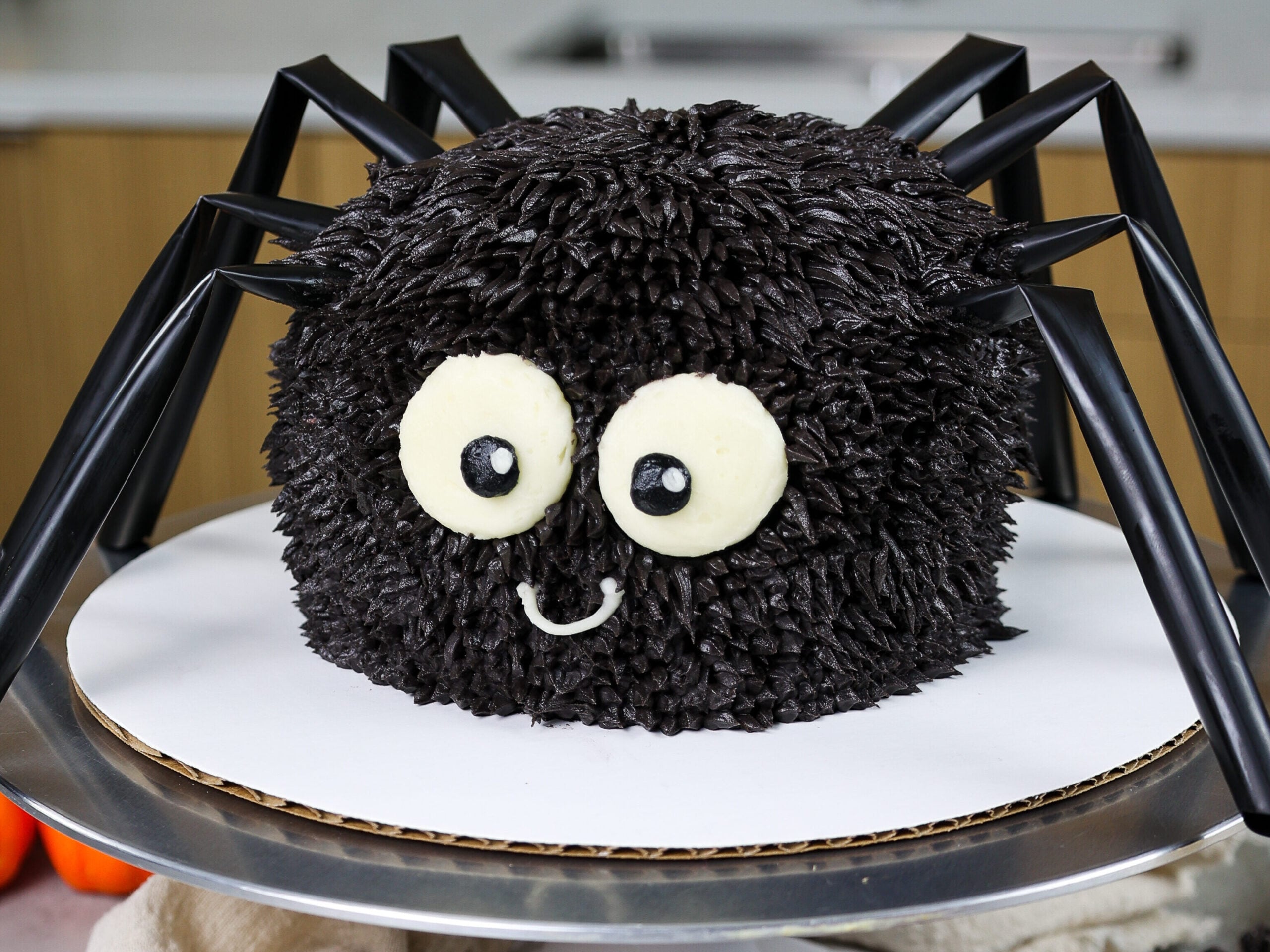 image of a cute halloween spider cake made with chocolate cake layers and chocolate buttercream frosting