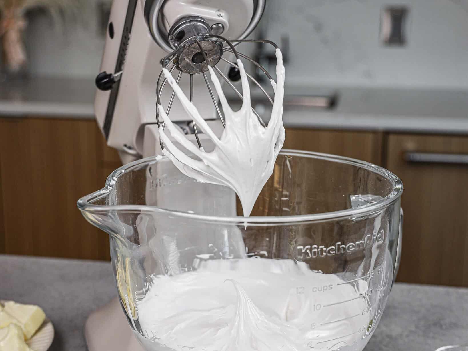 image of egg whites and powdered sugar that have been whipped to stiff peaks to make a not too sweet buttercream frosting