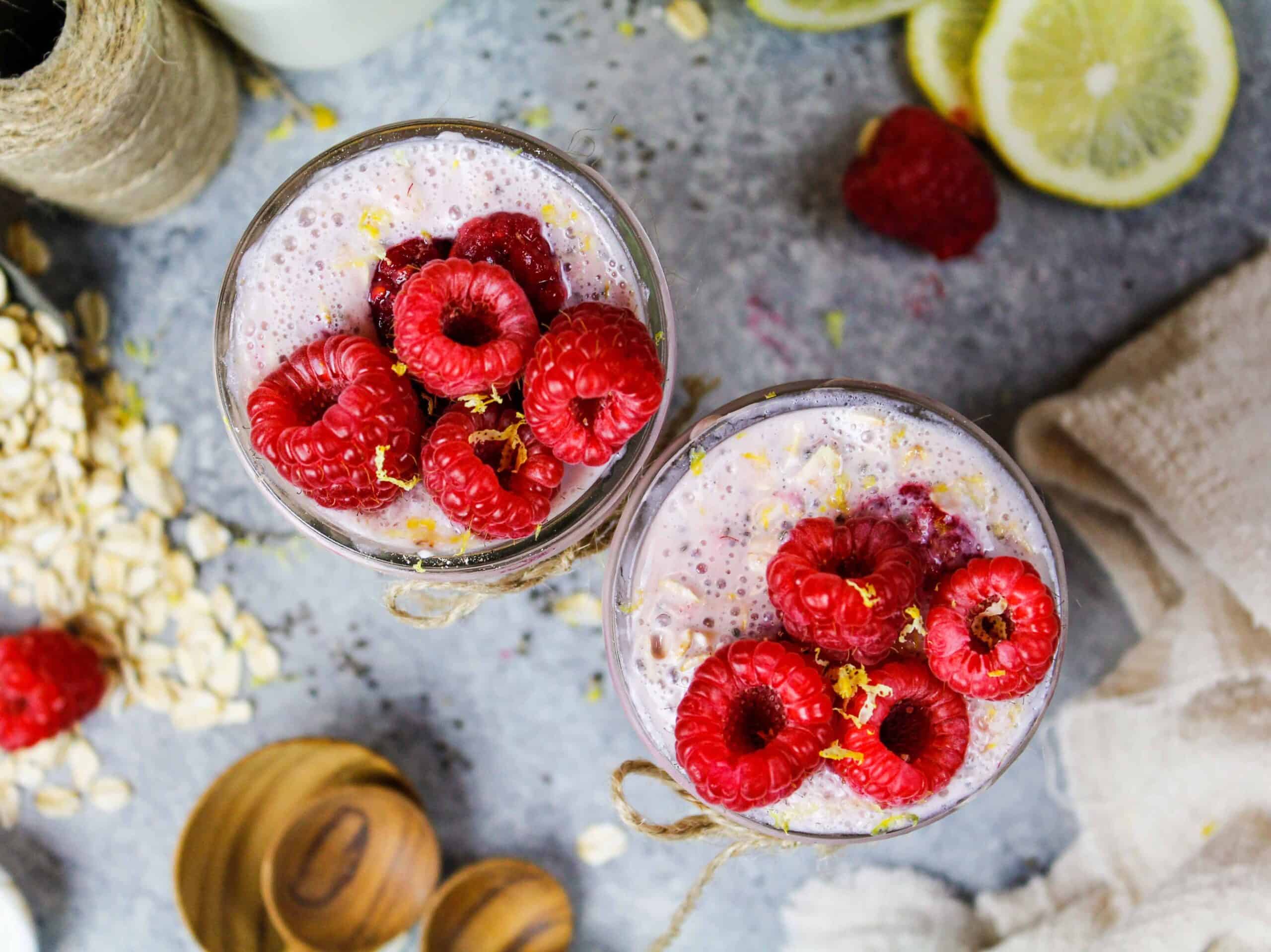 image of raspberry overnight oats that are topped with fresh raspberries and lemon zest