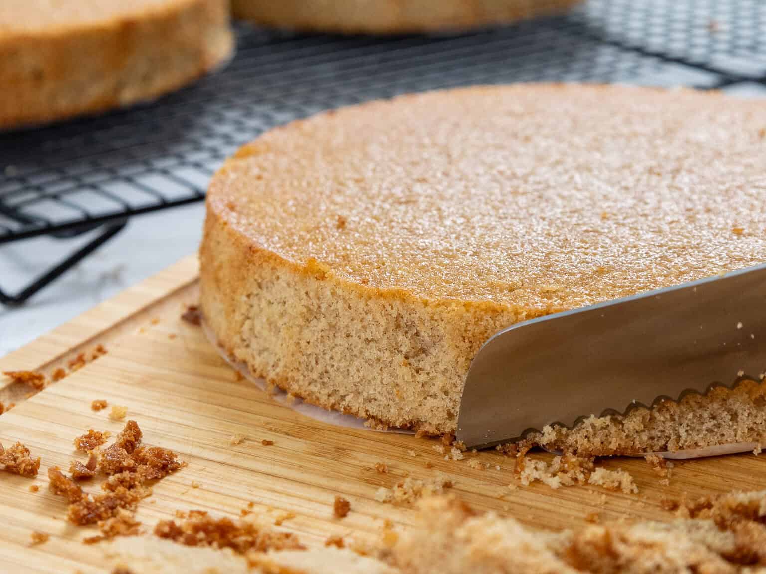 image of lotus biscoff cake layers being trimmed with a serrated knife