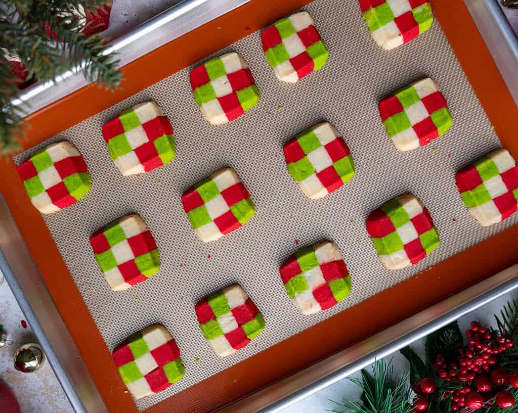 image of christmas checkerboard shortbread cookies that have been baked and are cooling on a baking sheet