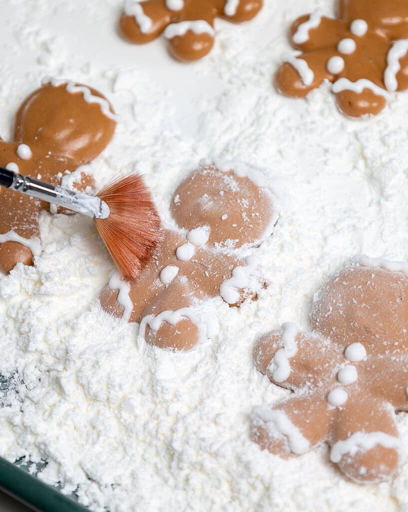 image of gingerbread marshmallows being dusted with cornstarch to prevent them from sticking