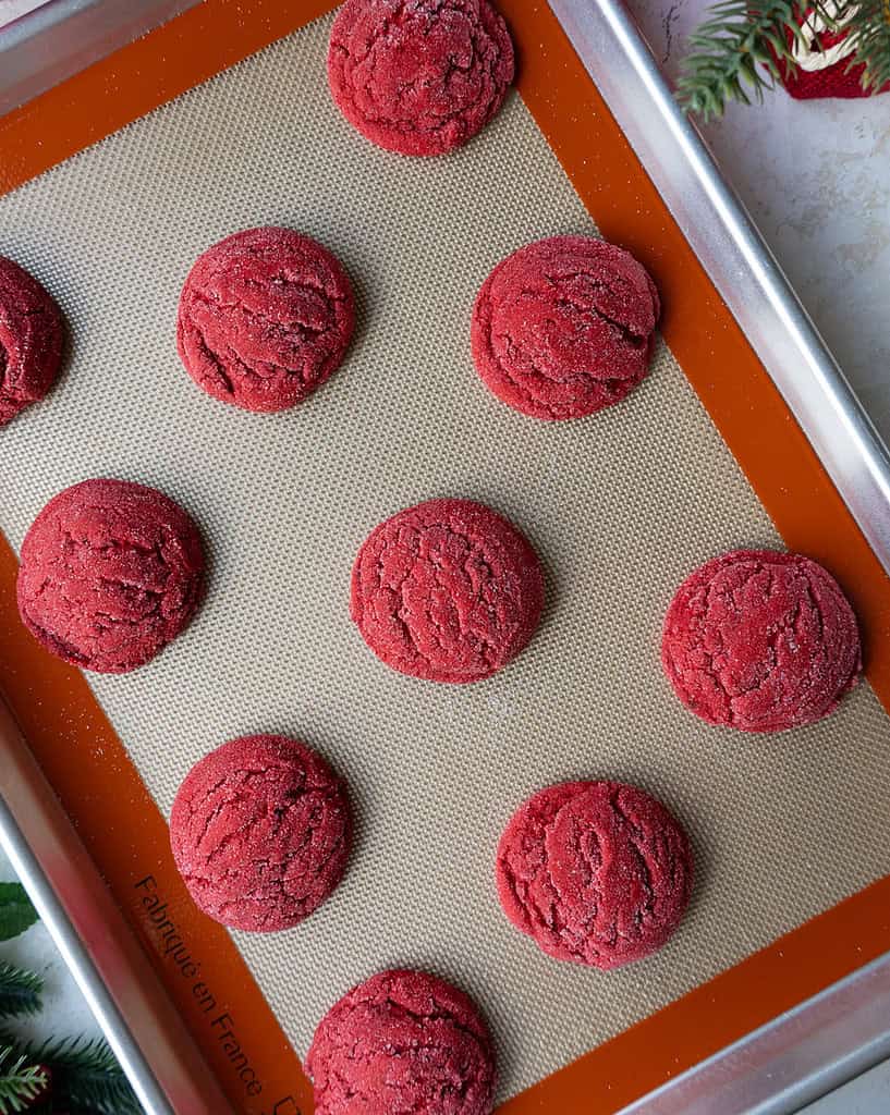 image of red velvet sugar cookies that have been baked on a baking sheet and are cooling