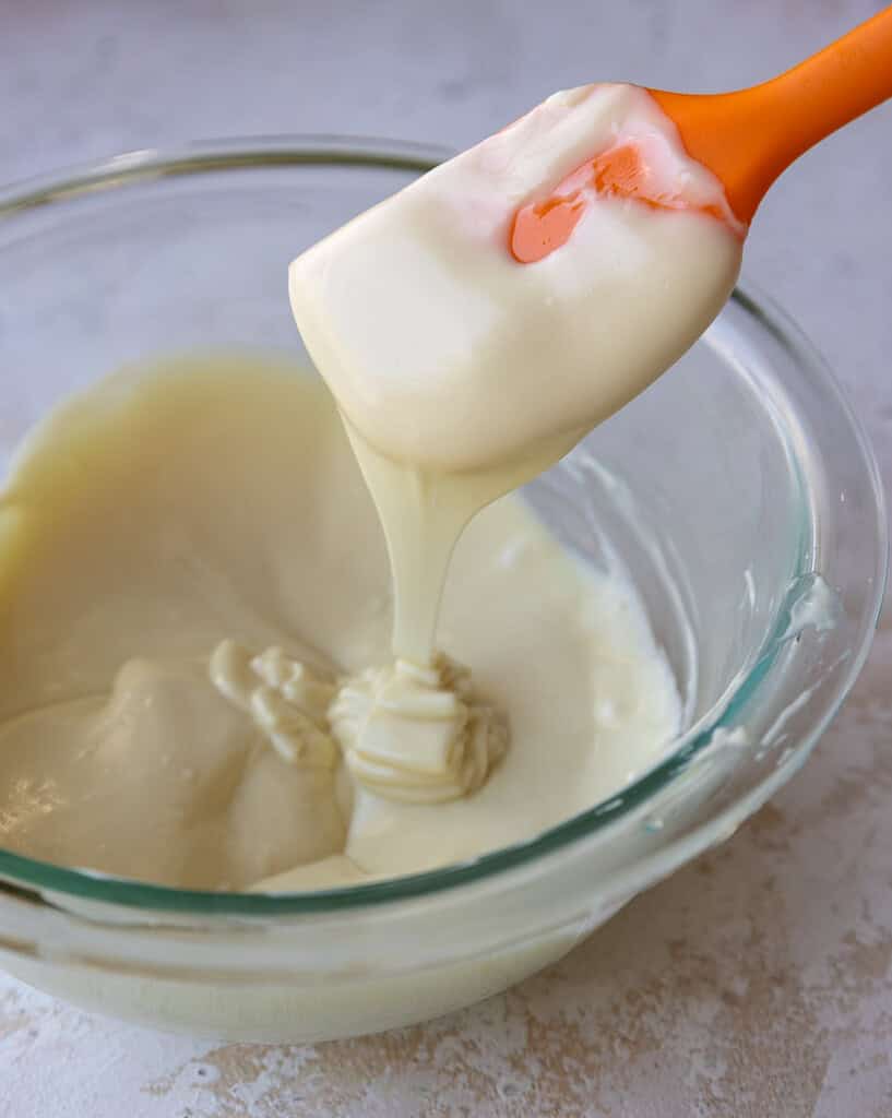 white chocolate that's been melted in a glass bowl