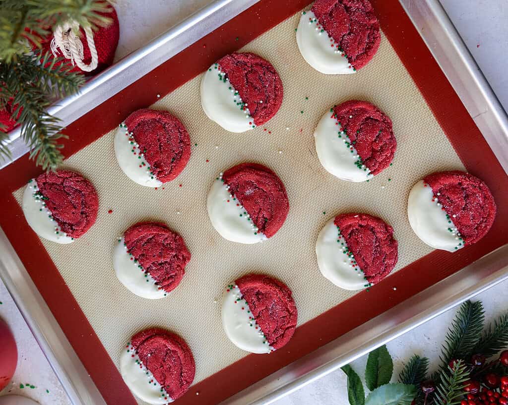 image of red velvet sugar cookies that have been dipped in white chocolate to make them snow-capped for christmas