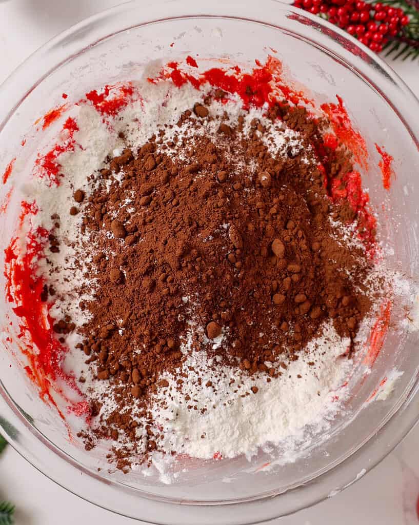 image of dry ingredients being mixed into wet ingredients to make red velvet sugar cookie dough