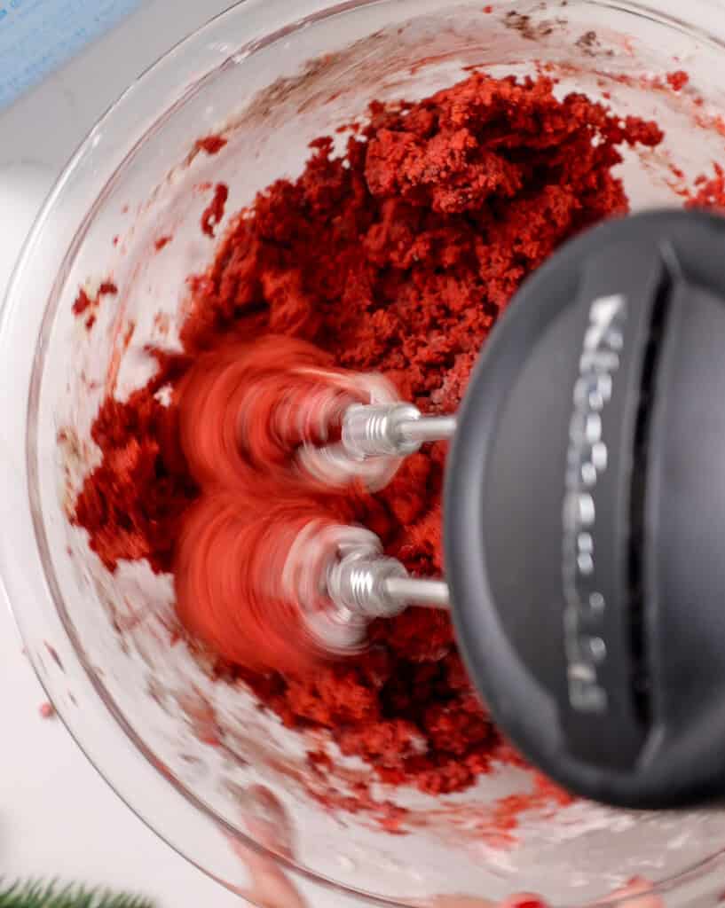 image of dry ingredients being mixed into wet ingredients to make red velvet sugar cookie dough