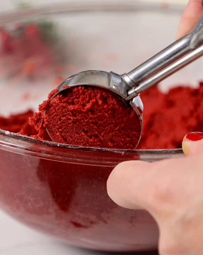 image of red velvet cookie dough being scooped out of a bowl using a 1 1/2 TBSP Cookie scoop