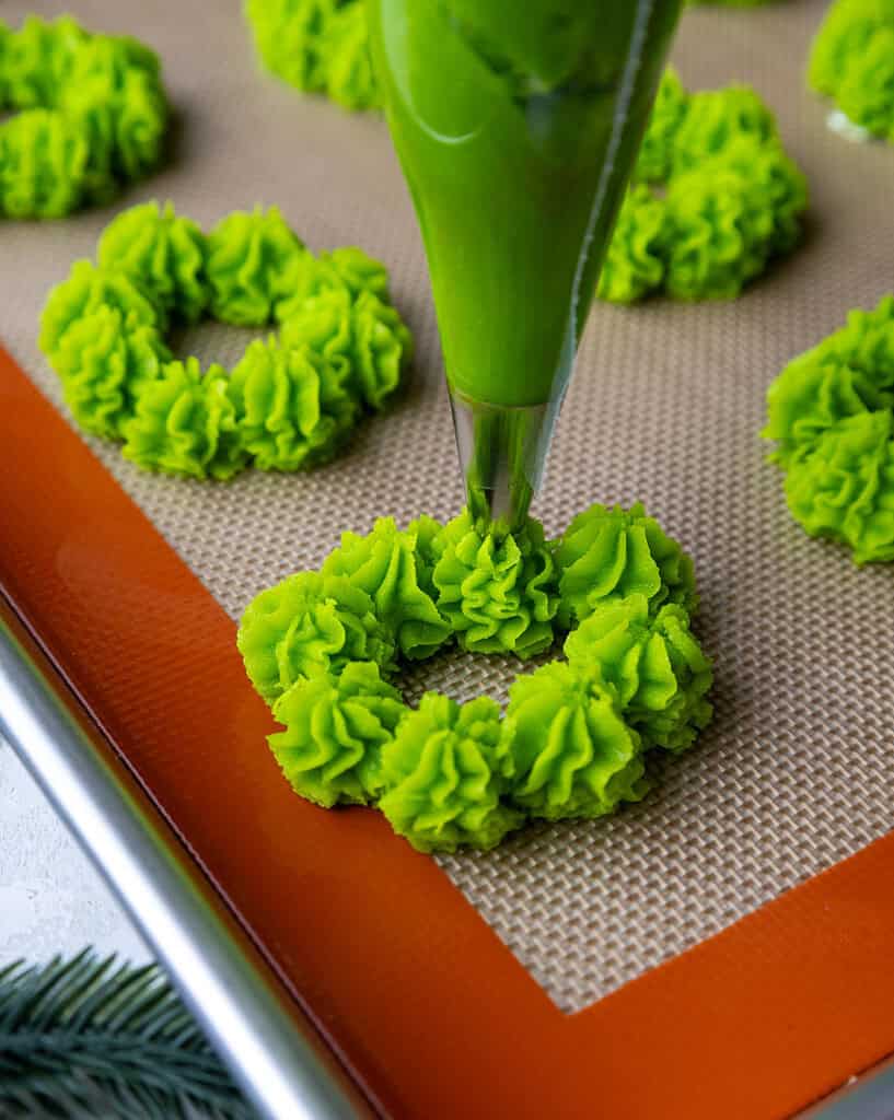 image of a christmas wreath cookie being piped with butter cookie dough