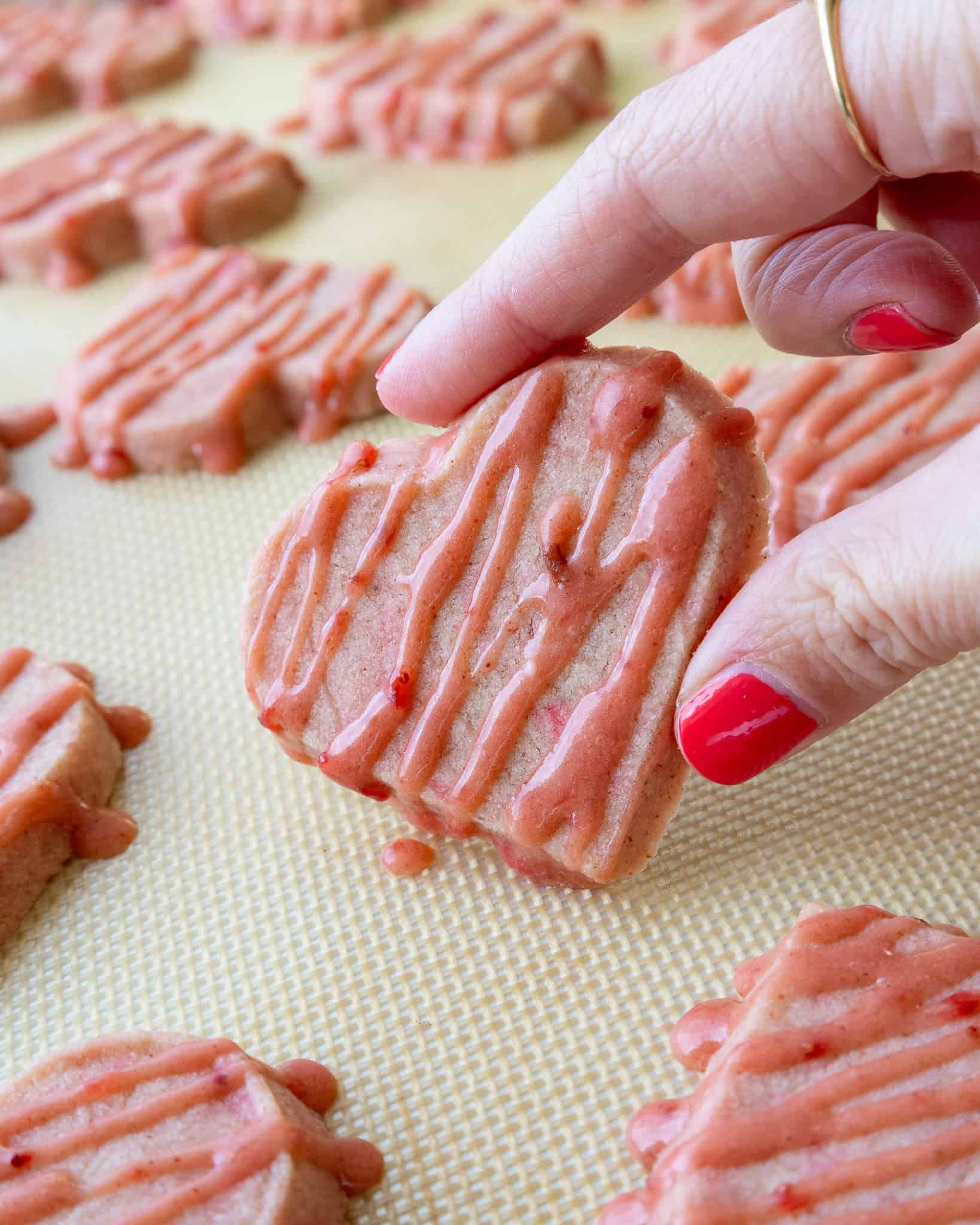 image of strawberry shortbread cookies that have been drizzled with a strawberry glaze