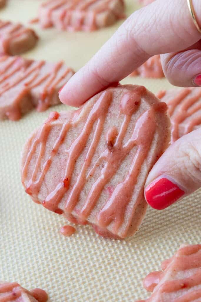 image of strawberry shortbread cookies that have been drizzled with a strawberry glaze